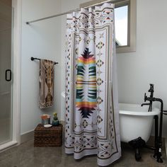 a bathroom with a bathtub, shower curtain and rug on the floor in front of it