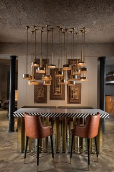 an elegant dining room with modern lighting fixtures and art work on the wall above it