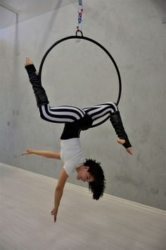 a man is suspended upside down on a hoop