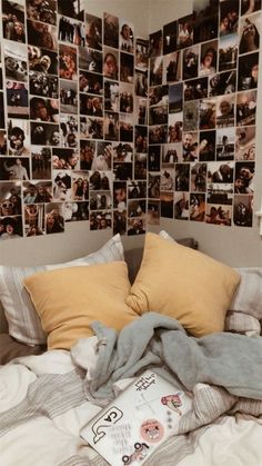 there is a bed with many pictures on the wall above it and a book laying on top