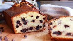 a loaf of cake sitting on top of a wooden cutting board next to chocolate chips