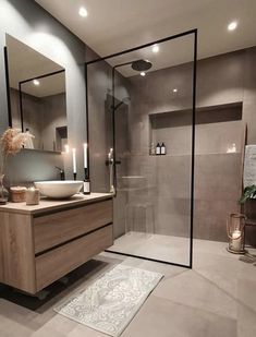 a bathroom with a sink, mirror and shower stall in the middle of it's walls