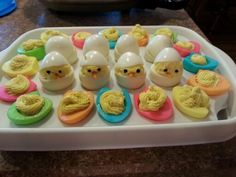 an egg tray filled with lots of different colored eggs and decorated like chicken's