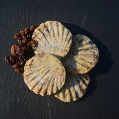 three seashells and some nuts on a black surface