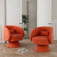 two orange chairs sitting on top of a hard wood floor next to a white door