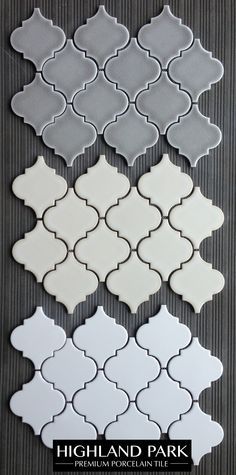 several white and gray tiles are arranged on the wall in different shapes, sizes and colors