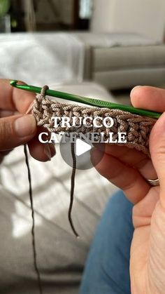 a person holding a green crocheted pencil with the words rico cathele written on it