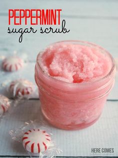 a jar filled with pink jello next to candy canes on a white table