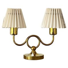 two lamps with white shades on them are next to each other and one light is turned off