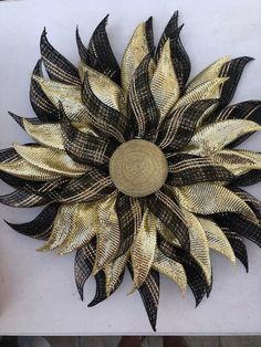 a gold and black flower on a white surface