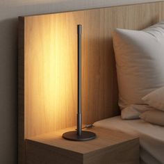 a lamp is sitting on a nightstand next to a bed