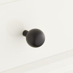 a black door knob on a white cabinet