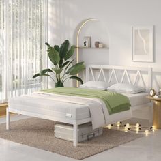 a white bed sitting in a bedroom next to a green blanket on top of a rug