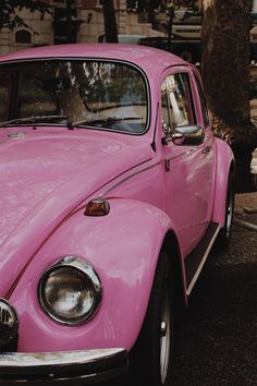 a pink car is parked on the side of the road