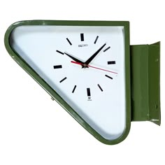 a green and white clock mounted to the side of a wall