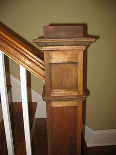 an old wooden grandfather clock sitting on top of a banister next to a stair case