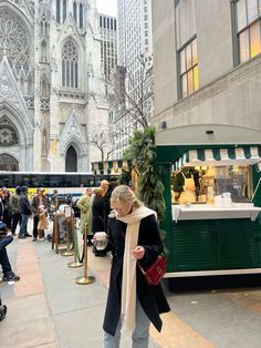 a woman is standing in front of a food truck on the street with people walking by