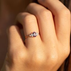 a woman's hand with a ring on it and three stones in the middle