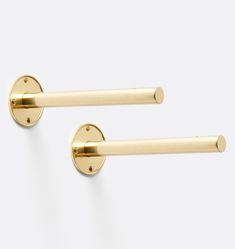 two brass door handles on a white wall