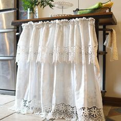 a white curtain hanging from the side of a table