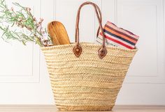 a straw bag with wooden utensils in it sitting on top of a table