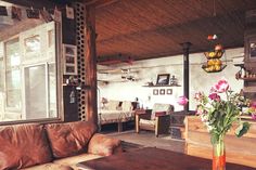 a living room filled with furniture and flowers in a vase on top of a table