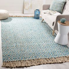 a living room with a couch, chair and rug on the floor in front of it