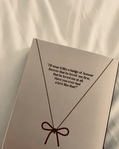 an open book on a bed with a string tied to it's front cover