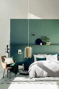 a bed room with a neatly made bed and green walls