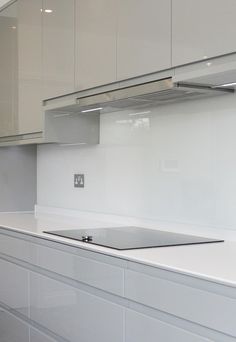 an empty kitchen with white cabinets and counter tops is seen in this image from the front view