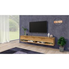 a large flat screen tv mounted to the side of a wooden entertainment center in a living room