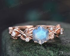 a close up of a ring on top of a rock with leaves and stones around it