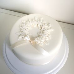 there is a white cake with flowers on the top and a ribbon around it's edge