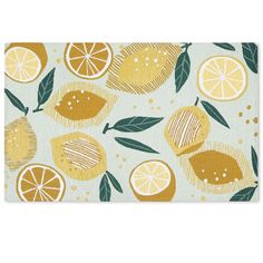 a placemat with lemons and leaves printed on the front, along with green leaves