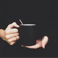 a woman holding a black cup with a straw in it