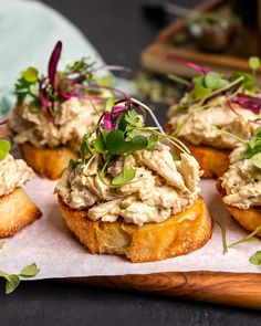 some food is sitting on top of a piece of paper and placed on a wooden board