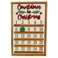 a wooden calendar hanging on the wall next to a white board with numbers and christmas decorations