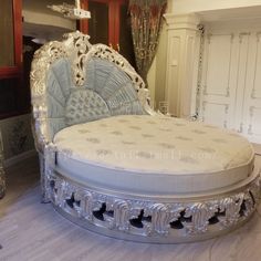 an ornate white bed sitting on top of a hard wood floor