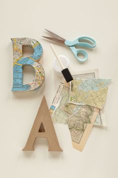 the letters are made out of old maps and other crafting supplies such as scissors