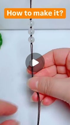 a person holding a string with beads on it and the words how to make it?