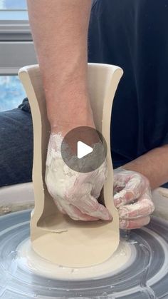 a person is making something out of clay on a potter's wheel with his hands