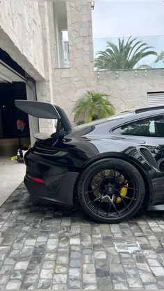 a black sports car parked in front of a garage