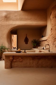 a kitchen with a sink and counter top in an adobe - style house, surrounded by stone walls