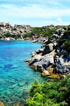 the water is crystal blue and clear with rocks on both sides, surrounded by greenery