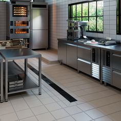 an industrial kitchen with stainless steel appliances and tile flooring is pictured in this image