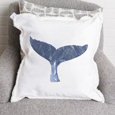 a white pillow with a blue whale tail on it