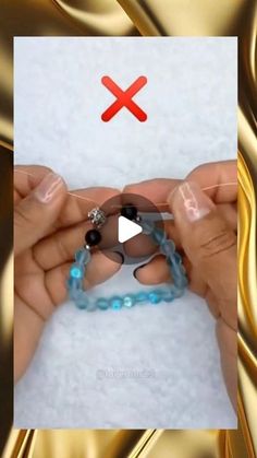 two hands are holding beads with one hand and the other has a red x on it