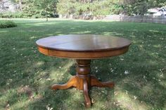 a wooden table sitting on top of a lush green field