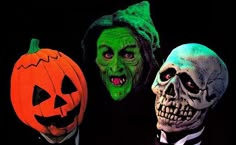 three people in halloween costumes with pumpkins and jack - o'- lantern masks