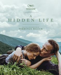 a movie poster for a hidden life with two people laying on the grass and kissing each other